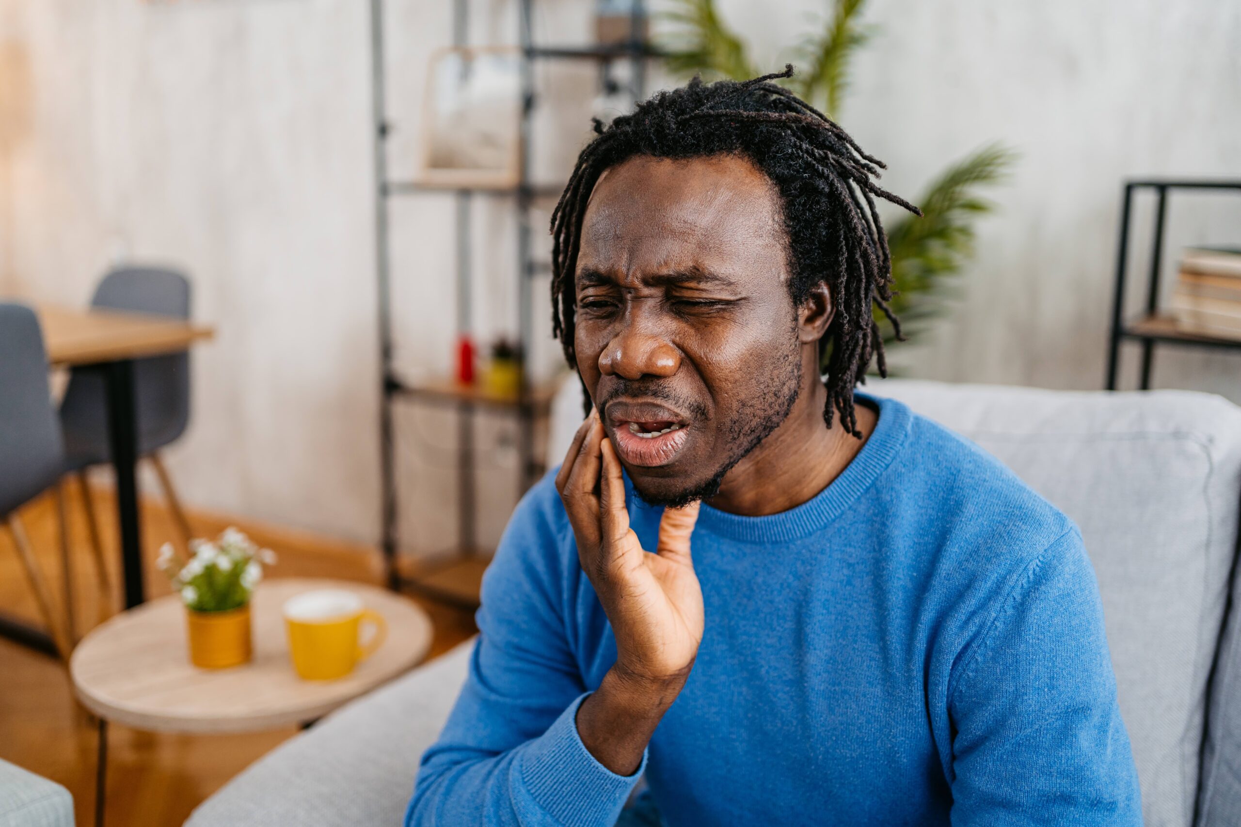 man with toothache holding his face